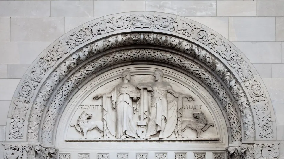 Carved stone arch over a savings bank entrance with the words Security and Thrift